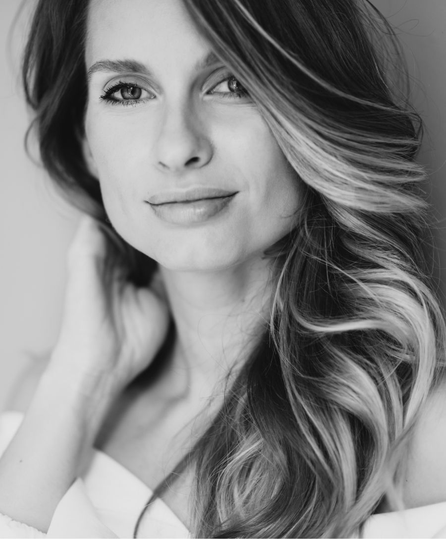 Smiling woman with blonde hair and blue eyes.