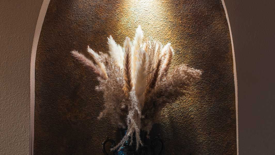 Pampas grass arrangement in decorative vase.