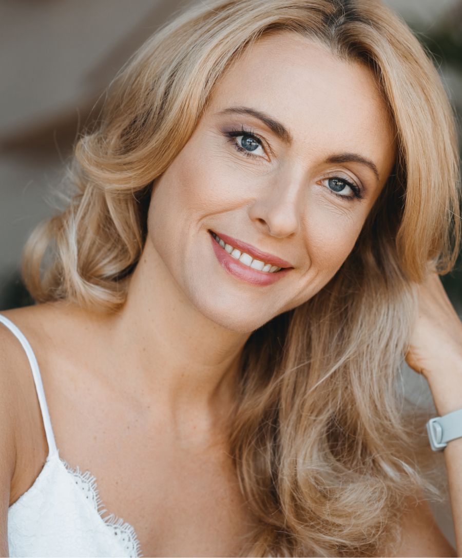 Smiling woman with blonde hair and blue eyes.