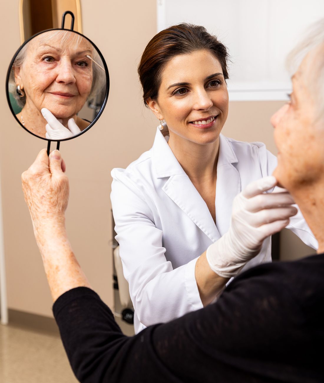 Dermatologist examining patient in consultation room.