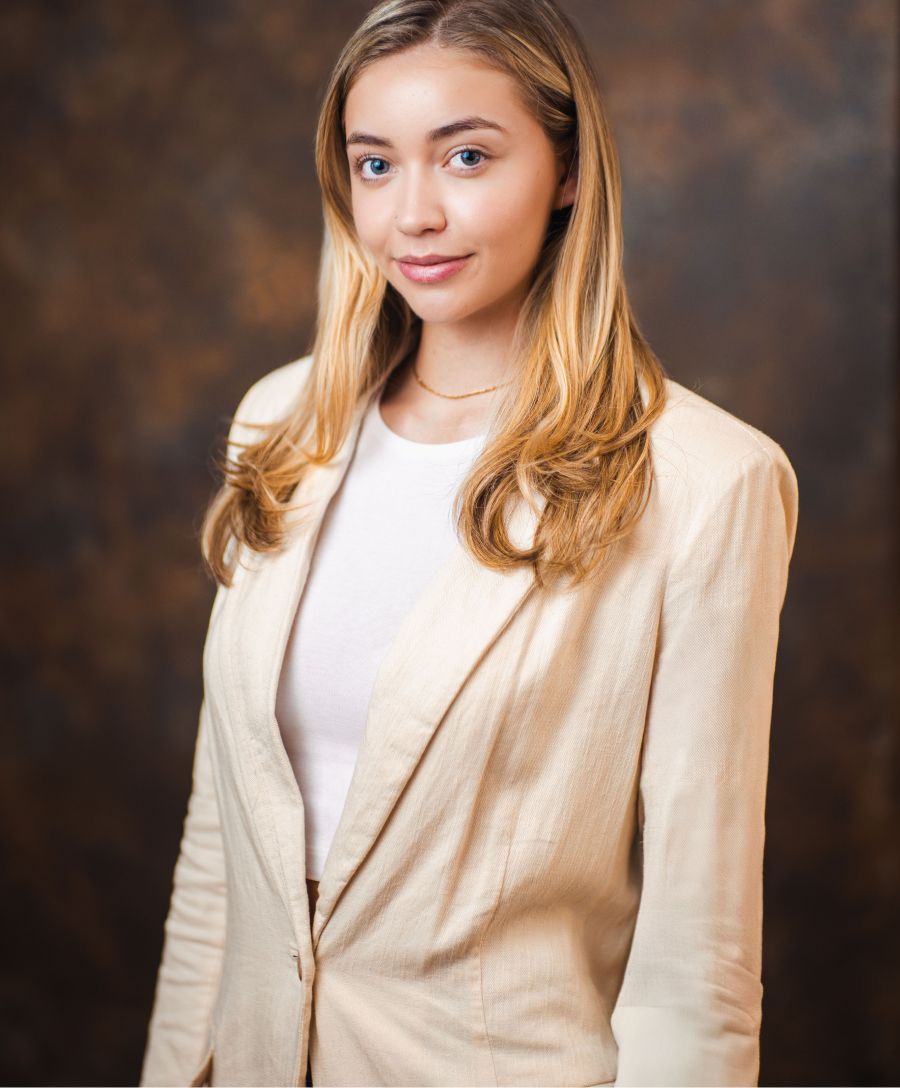Person in a cream blazer with soft lighting.
