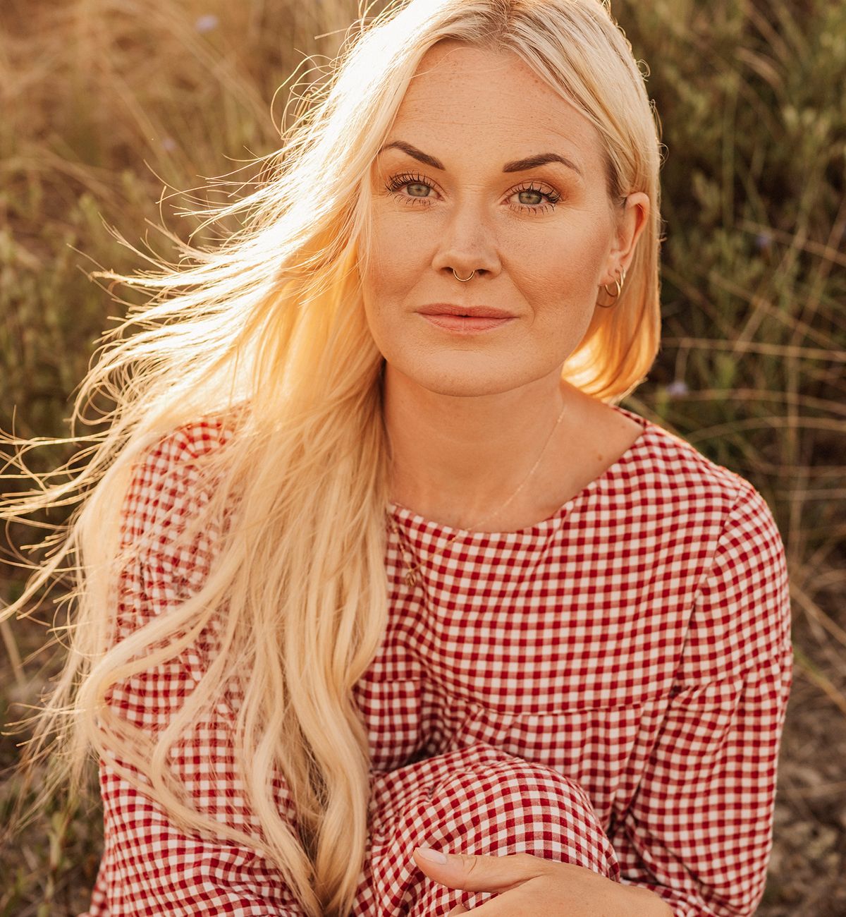 Woman with long hair in sunlit field.