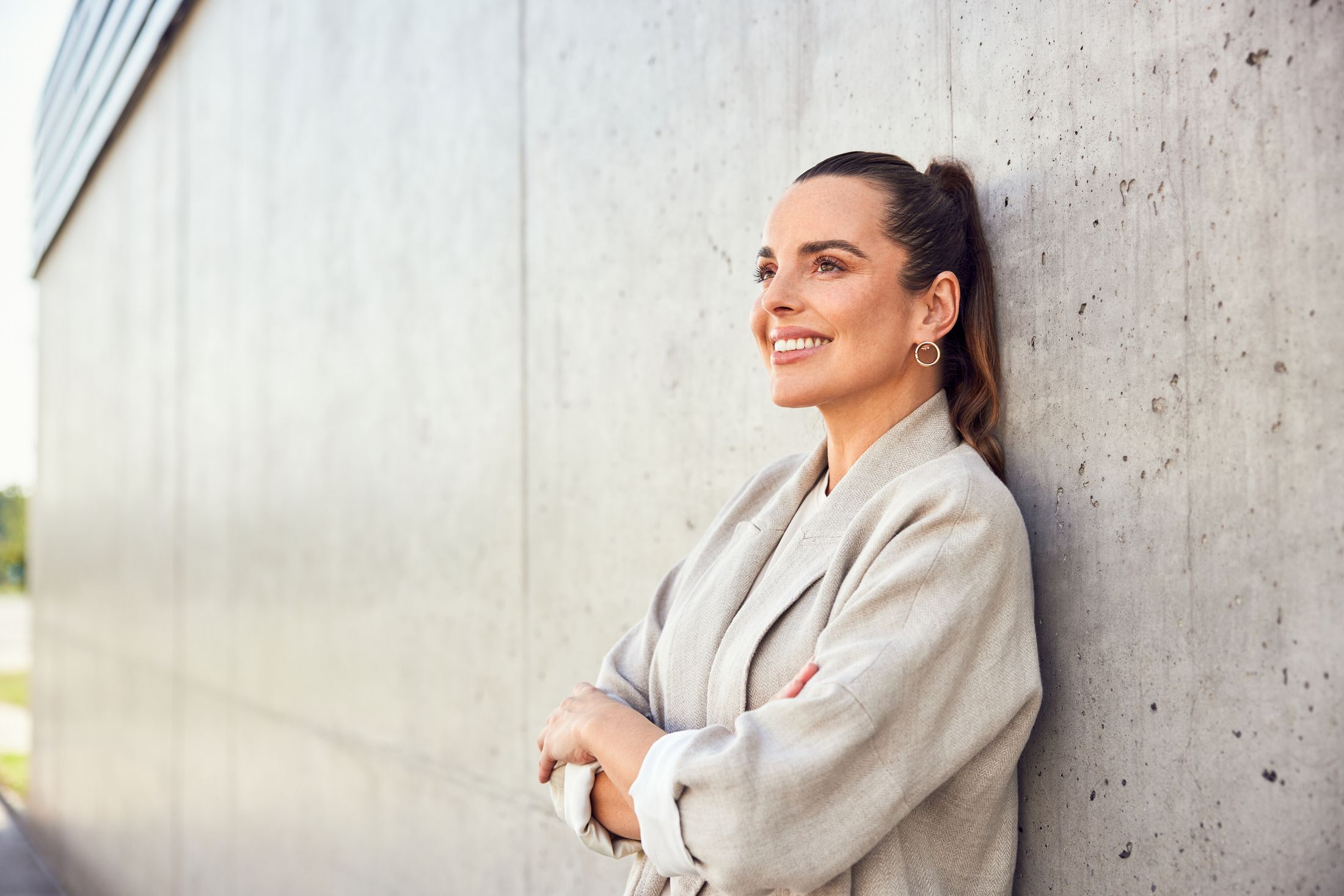 Smiling Albuquerque injectables model leaning against a concrete wall.