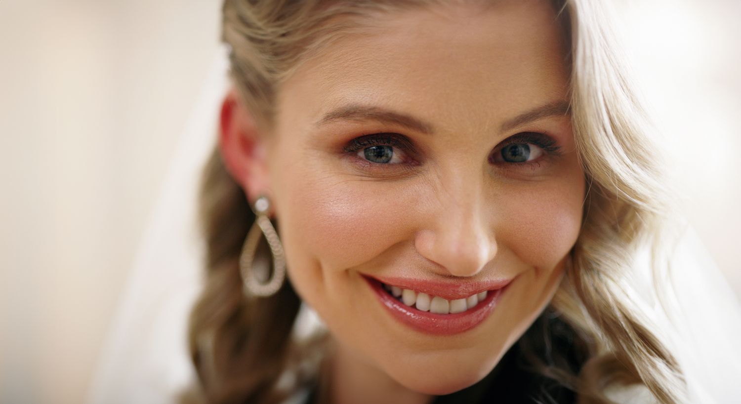 Smiling woman with natural makeup indoors.