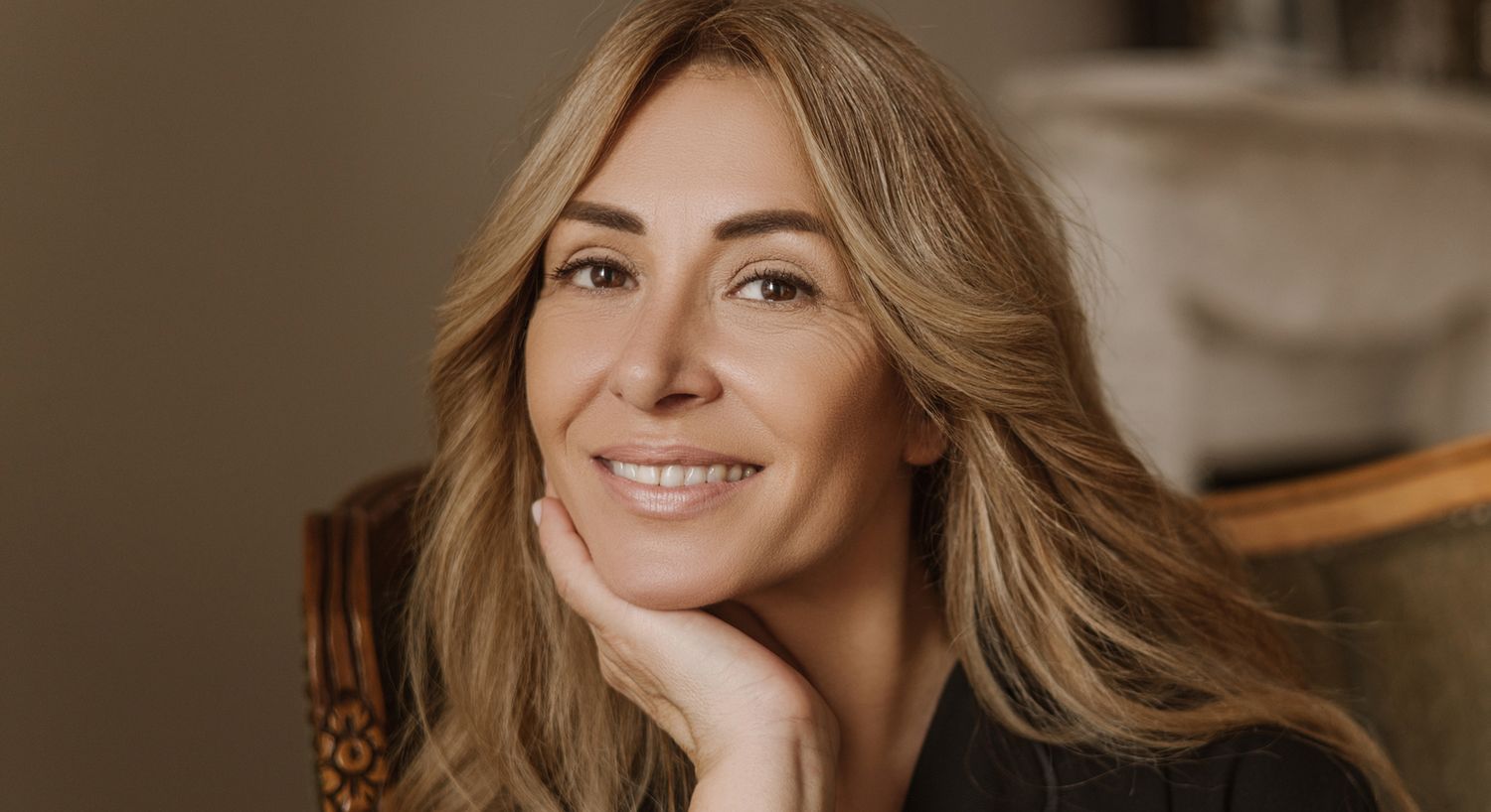 Woman smiling with long, wavy hair.